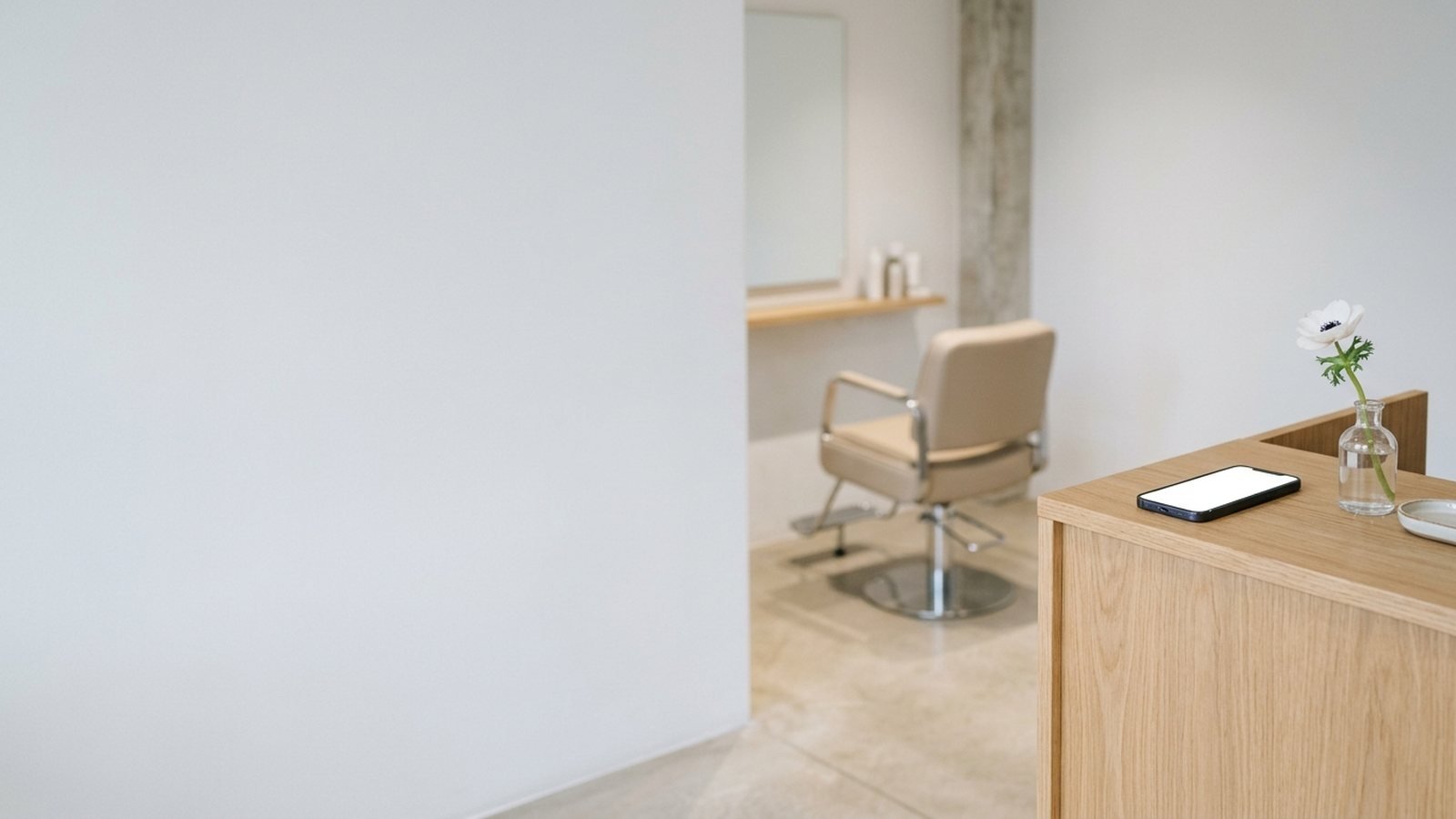 Sillón de un salón de peluquería con el móvil del encargado en el mostrador